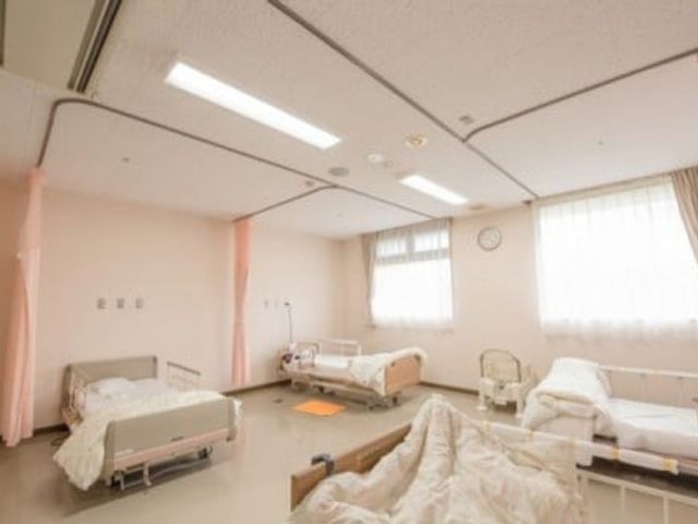 明るいベッド部屋 居室 自然光が差し込む明るい居室です。ベッド間にはプライベートを保つためのカーテンが設置されています。