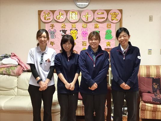 笑顔のスタッフと掲示物