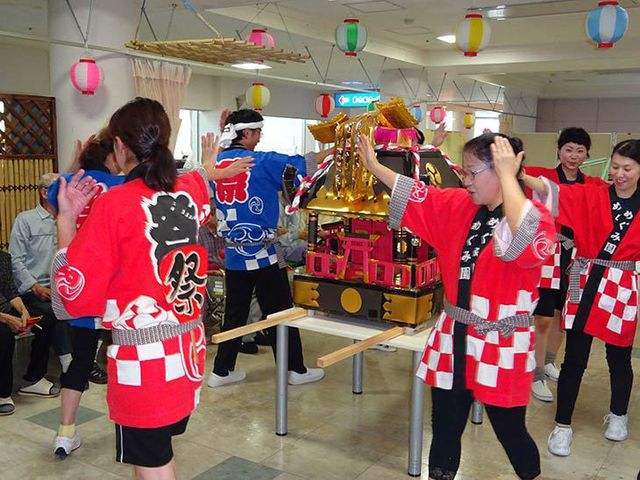 祭りの様子を楽しむエントランス エントランス エントランスでは、活気あるお祭りが行われています。スタッフも参加して和やかな雰囲気です。