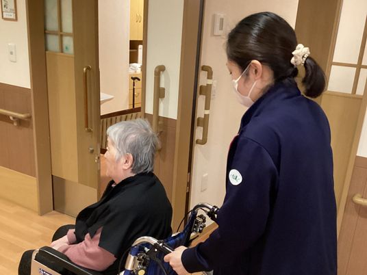 スタッフが車椅子を押す様子
