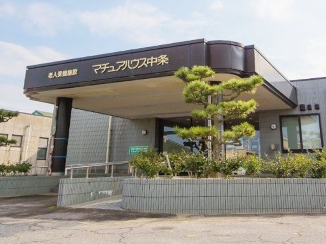 施設の外観 外観   落ち着いた色合いの建物正面に、手入れされた植栽が映えています。車椅子でも入りやすいようなスロープも見えます。