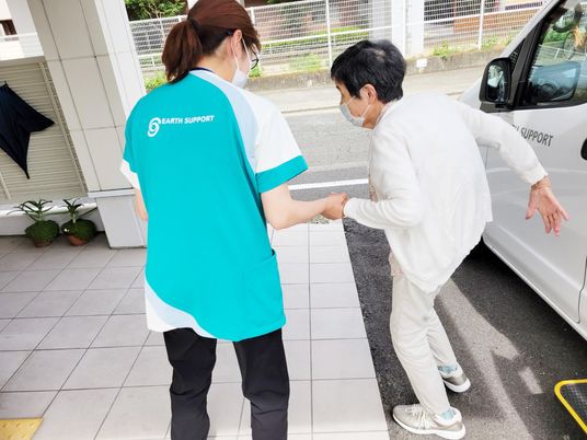 手を取るスタッフと高齢者の様子