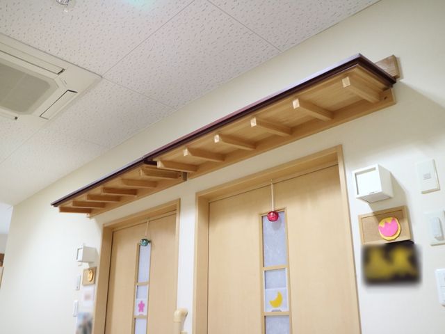 廊下の明るい装飾 廊下 落ち着いた色合いの廊下には心を和ます装飾が施されており、訪れる方々に安らぎの時間をご提供しています。モダンなデザインの扉も見え、こだわりのある空間作りが感じられます。