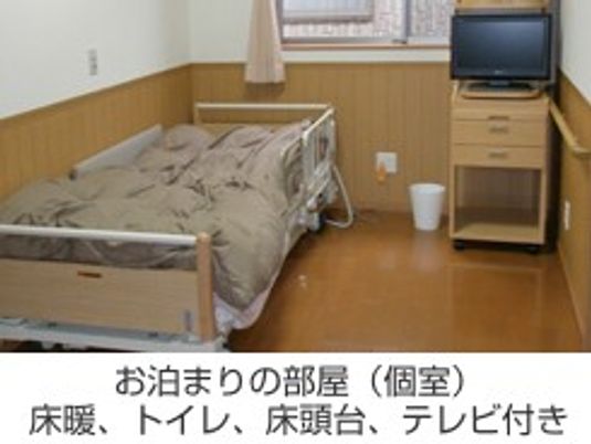 ベッドとテレビのある居室  