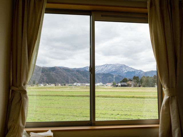 窓越しの自然景色眺望 居室 窓からは雄大な山々と緑豊かな野が広がり、ゆったりとした時間を過ごせる空間です。