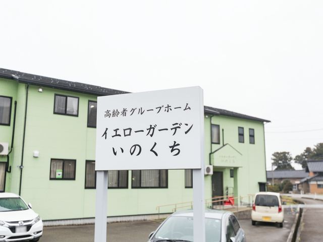 看板と外壁が緑の建物