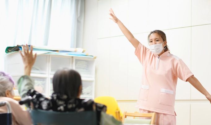 動きを指導するスタッフと入居者