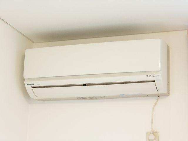 壁掛けエアコンのクローズアップ 居室 清潔で現代的なエアコンが設置されていて、年間を通じて快適な室温を保つことができます。