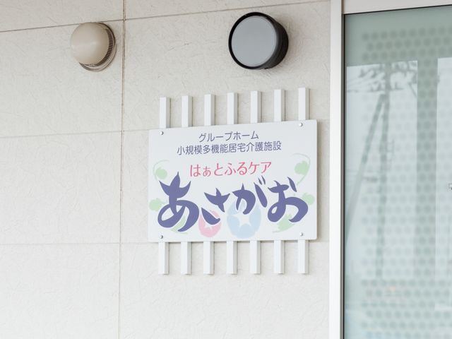 壁に掛かる案内板 外観 案内板には心温まるメッセージが記されており、訪れる人々を温かく迎え入れます。こちらはスタッフのイメージにも繋がるポイントです。