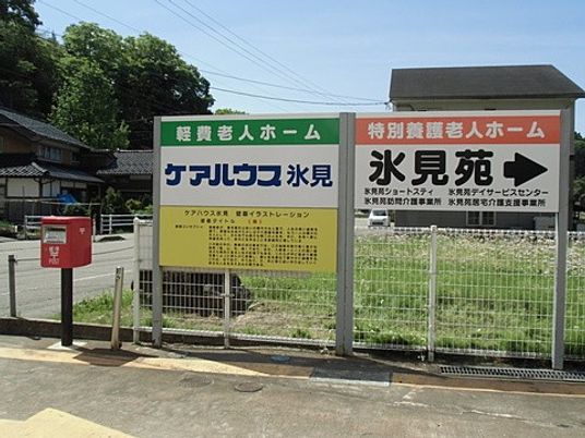 施設看板と郵便受けのある外観  