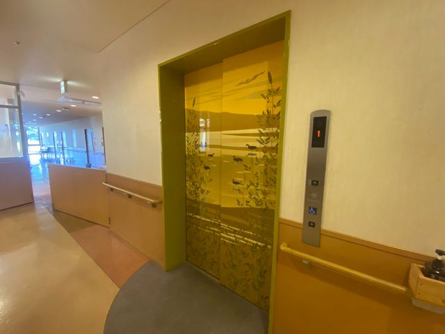 明るい廊下のエレベーター エレベーター 広々とした廊下に位置するエレベーターです。手すりが設置され、安全に配慮されています。