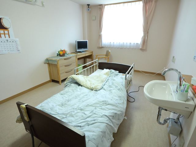 整理された明るい居室 部屋 ひとりひとりの生活スペースは、必要な家具が整えられており、日々の生活に安心感を提供します。こちらで働くことにより、快適な居室の環境を支えるお手伝いができます。