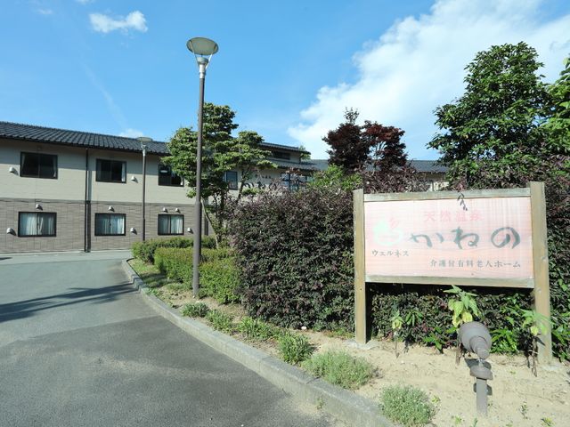 施設と看板の外観風景 入り口付近 落ち着いた色合いの建物と美しい緑に囲まれた外観です。穏やかな環境でお仕事ができる場所をお探しの方にぴったりです。