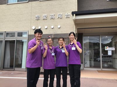 笑顔のスタッフが写る外観