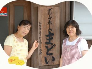 スタッフが看板前に立つ外観  