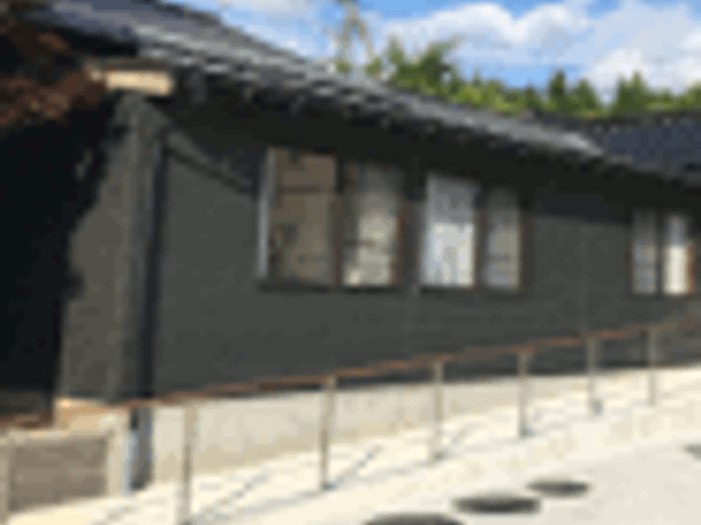黒い外壁と手すりの建物 外観 手すり付きの通路が備わった施設の入り口です。すっきりとしたデザインが魅力的です。