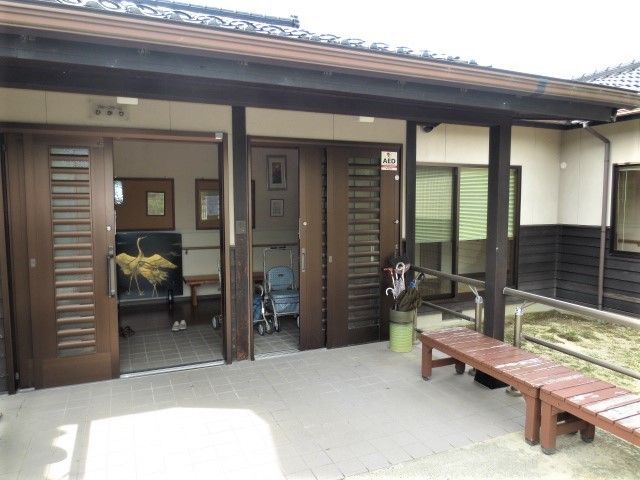 和風建築のエントランス 外観 落ち着いた雰囲気のエントランスで、座ってのんびりと外の風景を眺めることができる休憩スポットです。車いすを置いたままでも安心して立ち寄れる造りとなっております。