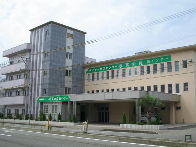 緑の看板の建物外観 外観 大きな窓が並ぶ施設の外観です。緑の看板が目立ち、訪問者を温かく迎えます。