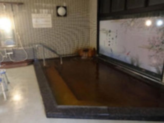 ゆったりとした和室 浴室 和の趣ある広々とした空間で、休息やくつろぎのひとときをお過ごしいただけます。壁には風景画があり、落ち着いた雰囲気を演出しています。