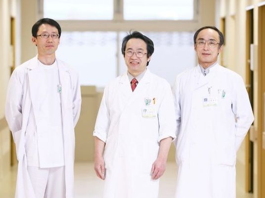 白衣の職員が並ぶ廊下  