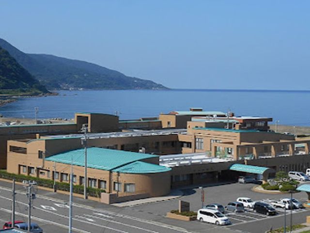 海沿いの建物外観 外観   海を望む立地に、落ち着いた色合いの建物が広がっています。車寄せや駐車スペースも見え、通勤動線をイメージしやすいです。