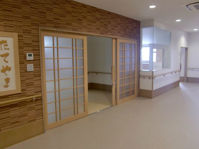 和風デザインの廊下 廊下 和風の引き戸が目を引く廊下です。手すりが設置されており、安全性が重視されています。