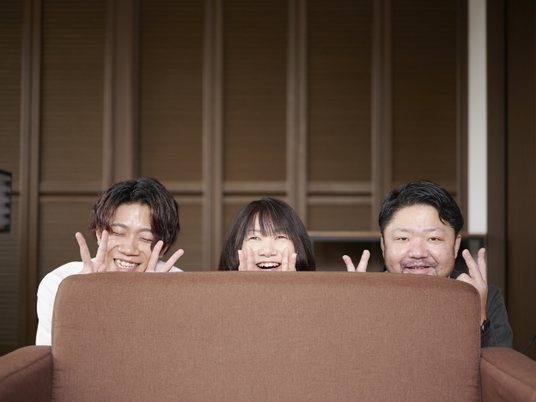 笑顔の3人が並ぶリビング  