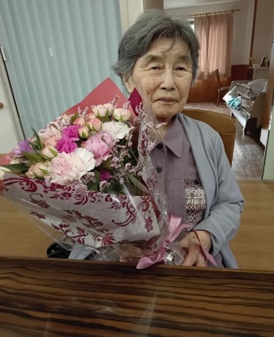 花束を持つ高齢の女性