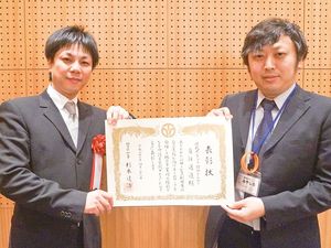 表彰状を持つ男性2人の様子  