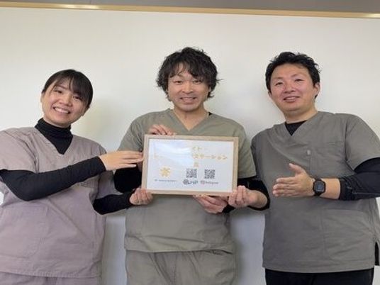 スタッフ3人が賞状を持つ室内  