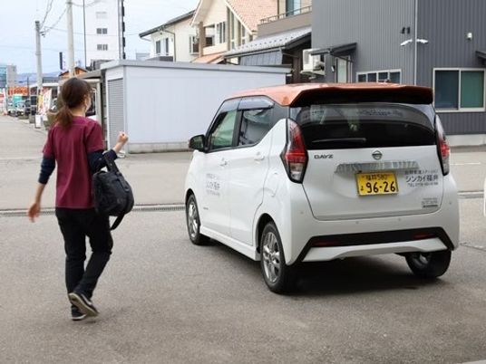 送迎車と歩く女性の外観  