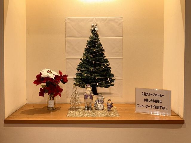 クリスマス装飾の廊下 玄関ディスプレイ 季節感のあふれる装飾を施された廊下の一角です。ここで人々が季節の移ろいを感じながら穏やかな時間を過ごしています。