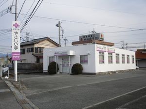 白い外観と看板の建物