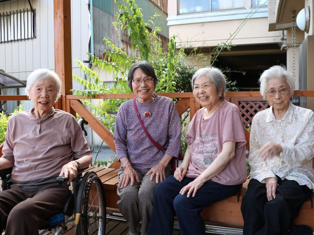 笑顔の高齢者たちの庭 庭 和やかな雰囲気の中、お庭で椅子に座りリラックスするステキな時間を過ごせます。