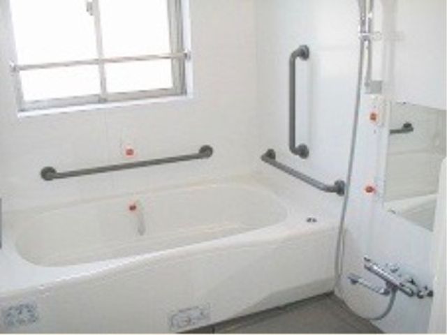 清潔な浴室設備 手すり付きの浴槽が特徴の洗練された浴室です。安全に配慮された作りで、快適な入浴時間を提供します。