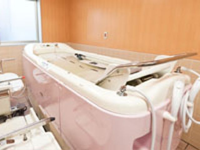 ピンク色の浴槽の浴室 浴室 機械浴が設置されたバリアフリーな空間です。安全で快適な入浴が可能になっています。