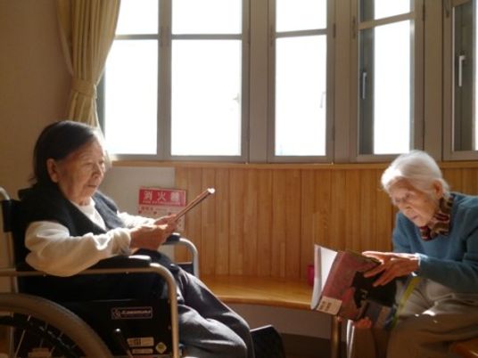 本を読む高齢者二人