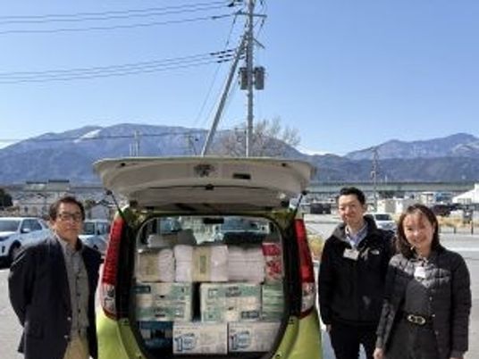 物資と並ぶ屋外の3人外観  