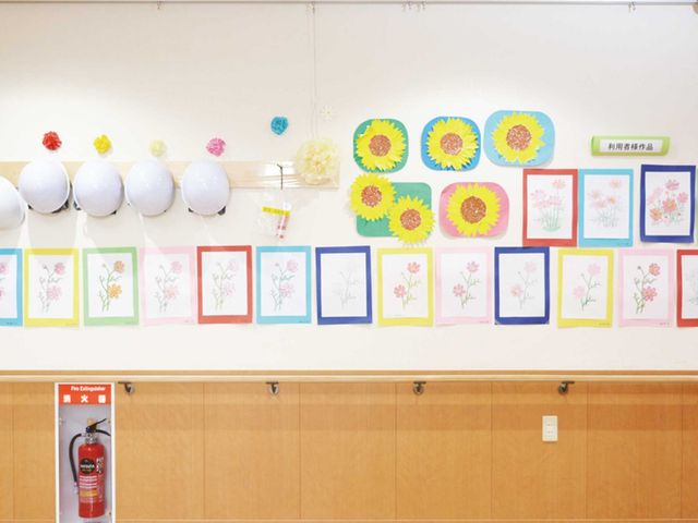 アート作品の掲示物 掲示物 利用者が制作した美しいアートが、壁一面に飾られています。施設の日常を彩る空間です。
