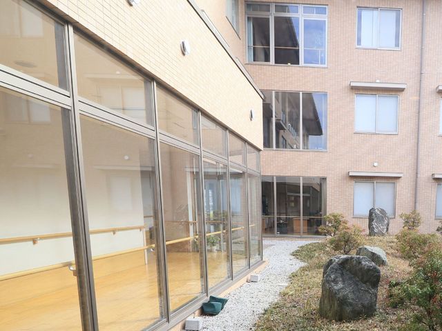 中庭を望む施設の様子 中庭 ゆったりとした中庭が眺められる、明るい空間のある環境です。日々の暮らしに癒しと安らぎを提供しています。