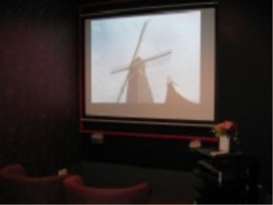 施設の写真 施設内に用意されているシアタールームでは、大画面で映画を見ることが可能となっている。座り心地の良いソファが置かれている。