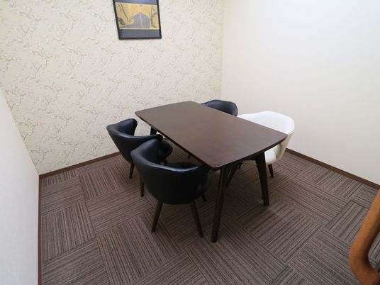 施設の写真 落ち着いた雰囲気の談話室である。テーブルにクッション性のある椅子が４脚配置されている。壁には絵が掛かっている。