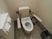 サムネイル 施設の写真 落ち着いた色合いのトイレには、暖房便座付きの便座が設置。可動式の手すりとケアコールも備えつけられている。