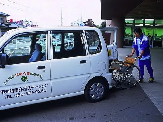 送迎車と車椅子の玄関前  