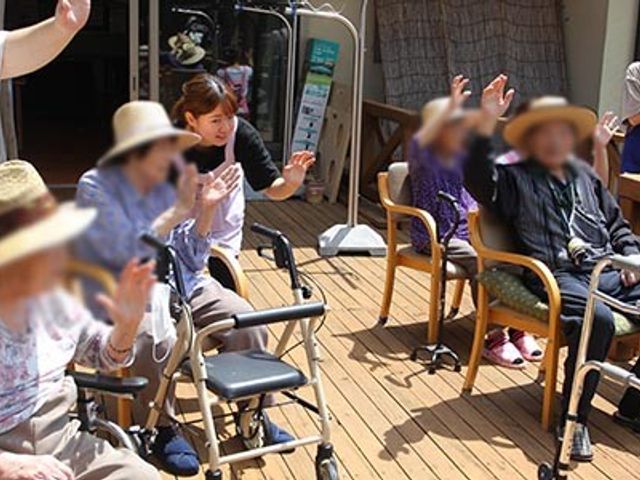 明るいテラス テラス 陽光が差し込むオープンスペースで、利用者が和やかにひとときを過ごしています。