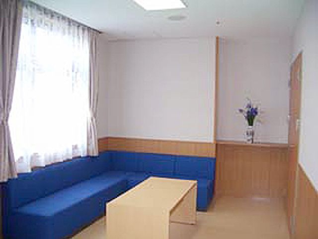 明るい休憩室の風景 休憩室 落ち着いた青色のソファが配置された、自然光が差し込む明るいスペースです。