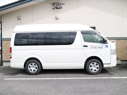 白い送迎車と建物