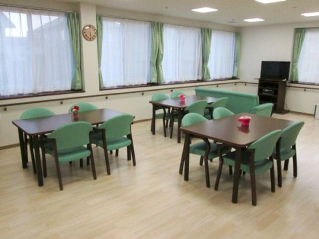 共用食堂の明るい空間 ダイニング 広々とした食堂では、ゆったりとした食事の時間を過ごすことができます。周囲に窓が多く、自然光が心地よい雰囲気を演出しています。