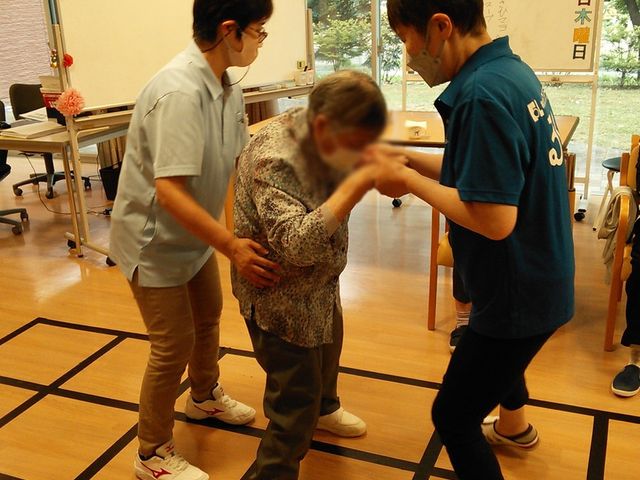 訓練室でのサポート 機能訓練室 スタッフが利用者を親切にサポートしています。温かい雰囲気の中で、安心して訓練ができます。