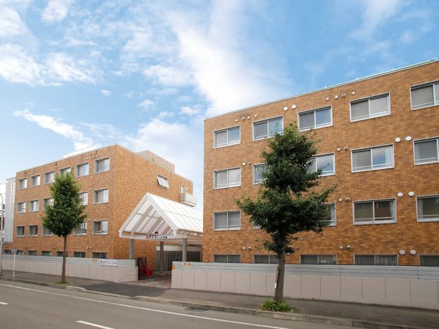 茶色の建物とエントランス 外観 明るく広々としたエントランスが目を引き、清潔感あふれる建物が印象的です。